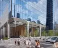 Busy urban intersection with modern glass skyscraper with silver architectural details