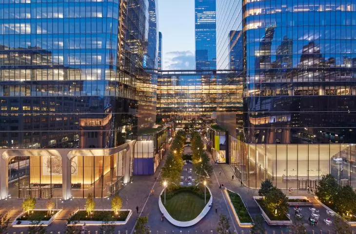 Modern skyscrapers with glass facades and illuminated interiors at dusk