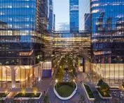 Modern skyscrapers with glass facades and illuminated interiors at dusk