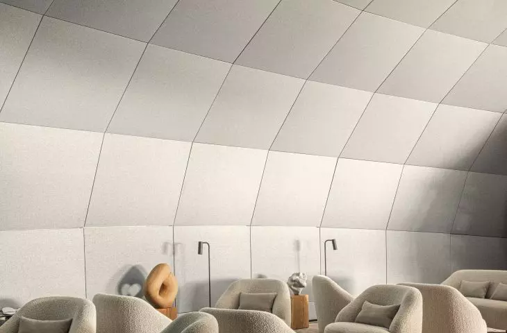 Modern interior with large gray armchairs, floor lamps and light gray panelled wall