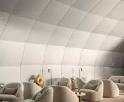Modern interior with large gray armchairs, floor lamps and light gray panelled wall