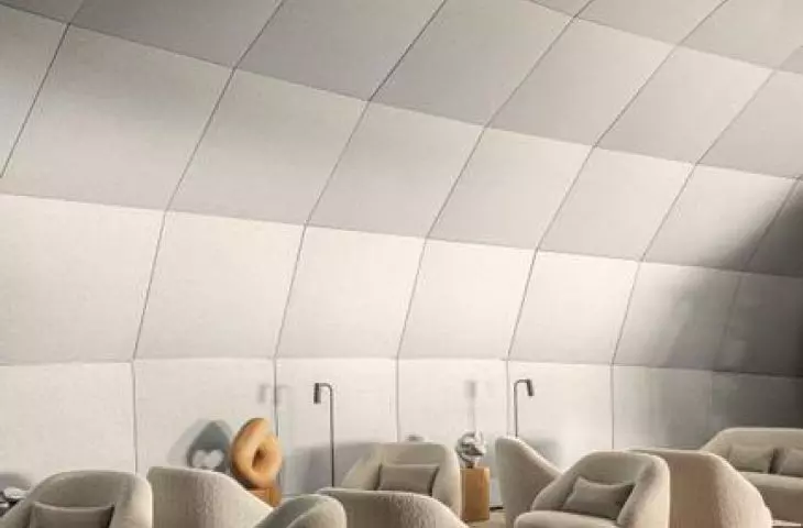 Modern living room with cream streamlined armchairs, round tables and bright curved ceiling