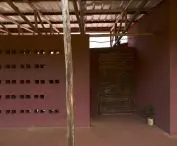 Interior view with dark red plaster walls and wooden post supporting the roof