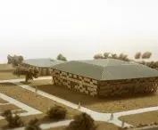 Architectural model of the main campus building surrounded by paths and miniature trees
