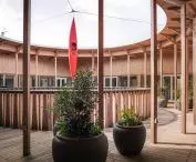 Round wooden courtyard with open roof decorated with plants in large pots