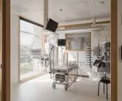 Hospital room with metal crib surrounded by medical equipment and monitors