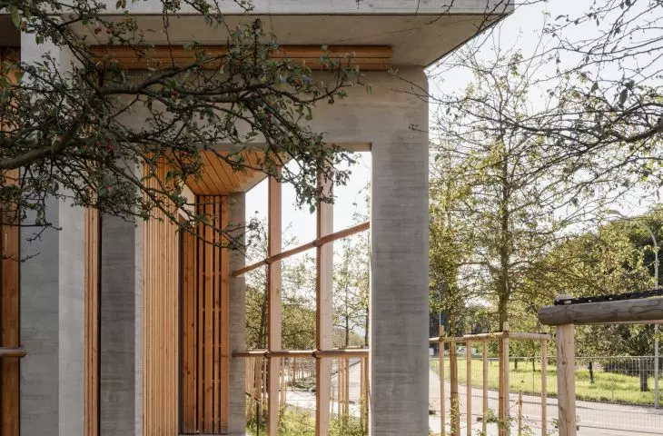 Modern concrete and wood architectural structure with surrounding greenery