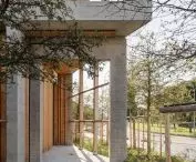 Modern concrete and wood architectural structure with surrounding greenery