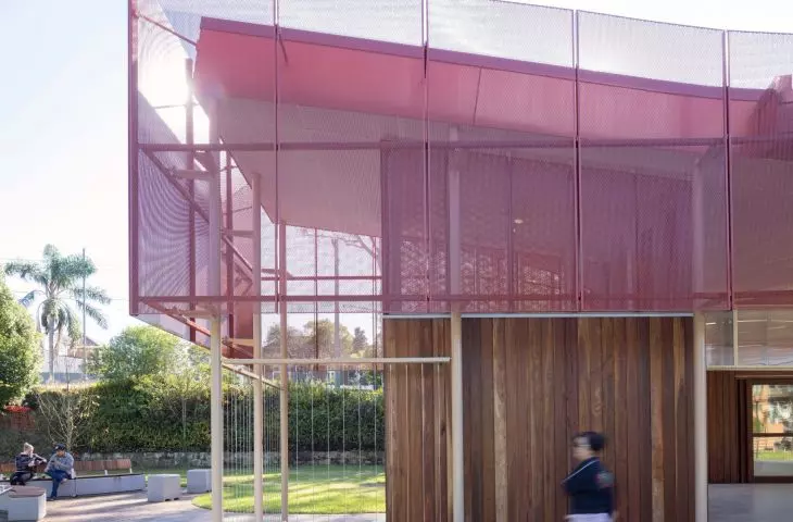 The façade of the pavilion in Hurlstone Park is covered with perforated red sheet metal, giving it a lightweight look