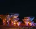 Wooden installation with glowing orange and red light against a starry night sky