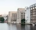 View of several multi-story modern and traditional buildings along the riverbank