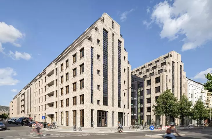 Modern multi-story light brick building on street corner
