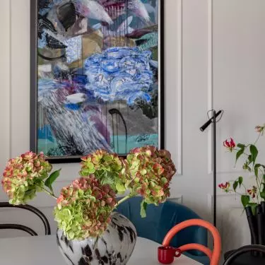 The living room features a painting by Paul Kino