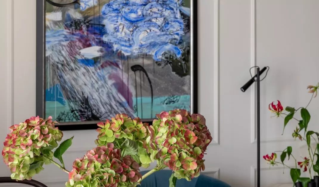 The living room features a painting by Paul Kino