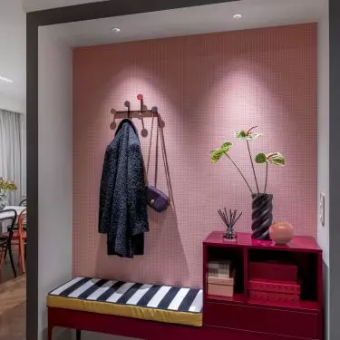 The alcove in the hall was furnished with a fuchsia dresser with a seat