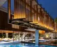 Modern house with illuminated wooden slats, glass walls and a pool at dusk