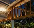 Modern building by the pool at night, lush tropical vegetation all around