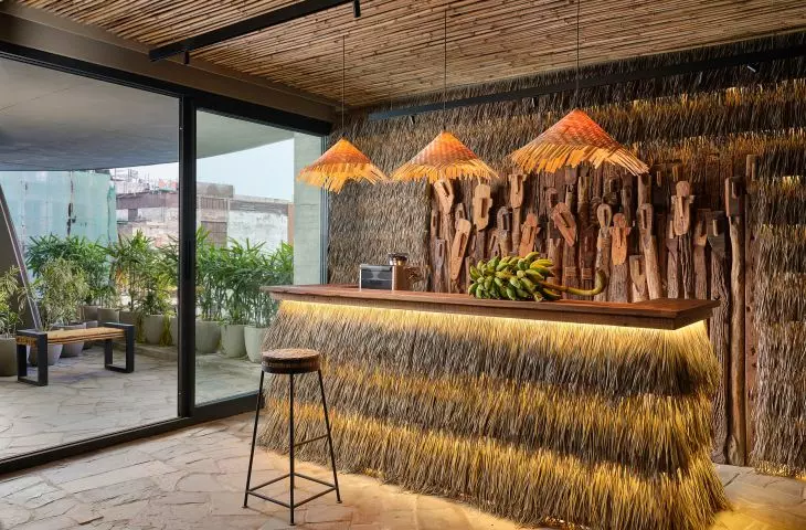 Tropical-style bar with straw and wood decor, lit by warm lights