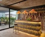 Tropical-style bar with straw and wood decor, lit by warm lights