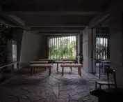 Interior with concrete walls, wooden furniture and openwork window
