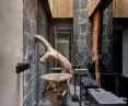 Modern bathroom with stone walls, bamboo ceiling and artistic wooden sink