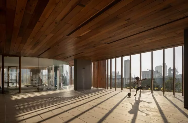 A gym and yoga terrace on the recreation floor of the Carmichael residential high-rise offers residents a place to relax and be active surrounded by natural greenery, supporting the building's eco-friendly character