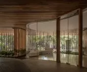 The lobby of the Carmichael residential high-rise impresses with its modern design, where rounded glass walls surround lush vegetation