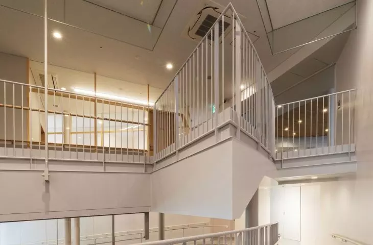 Widok wnętrza nowoczesnej wielopoziomowej przestrzeni ze świetlikiem i białymi balustradami