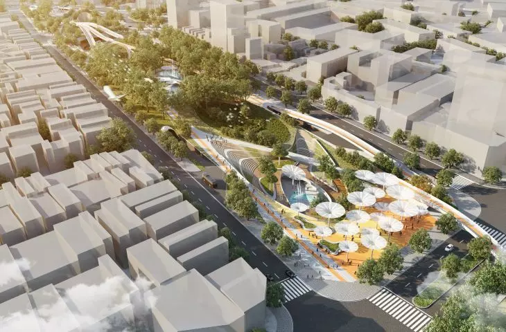 Aerial view of city park with paths, greenery and umbrella-like structures surrounded by city buildings