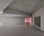 Spacious interior with concrete walls, large windows and pink accents