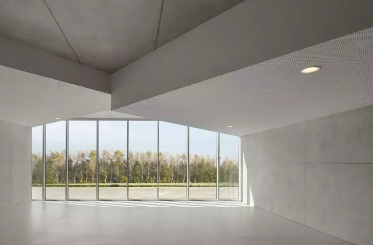 Spacious room with large windows, finely suspended ceiling and view of trees