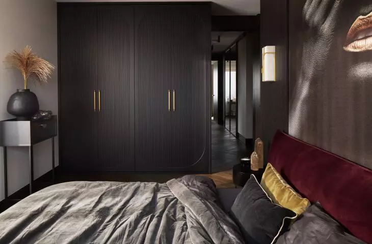 The bedroom is dominated by dark colors