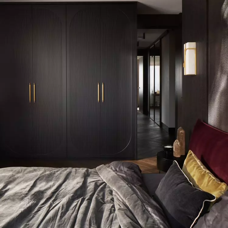 The bedroom is dominated by dark colors