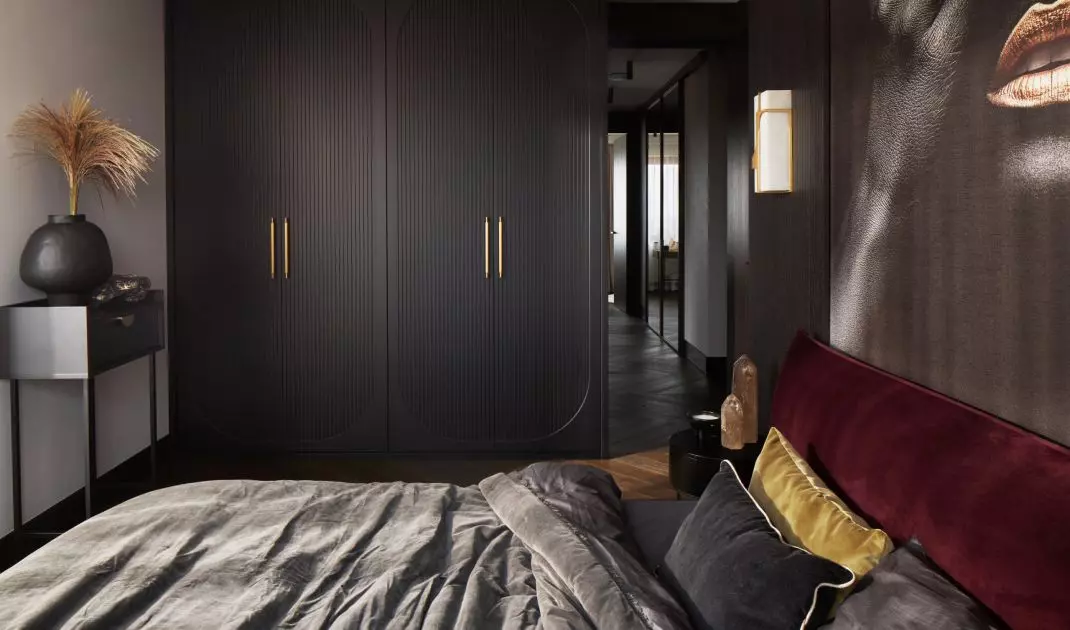 The bedroom is dominated by dark colors