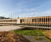 Modern building with wooden panels and vertical roof columns