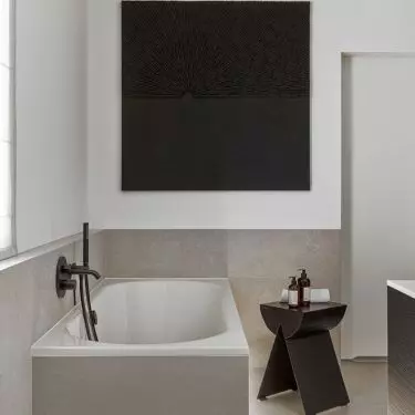 Above the bath hangs a painting by Anna Wywiał