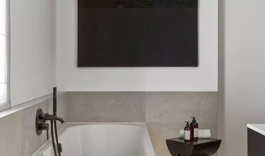 Above the bath hangs a painting by Anna Wywiał