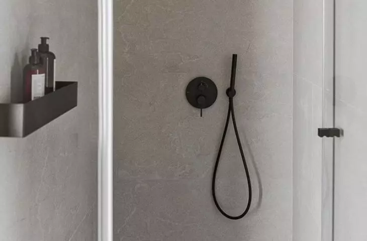 The interior of the shower was covered with gray tiles with white lining