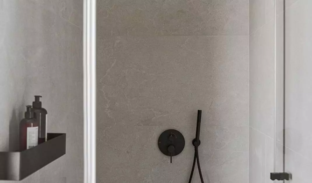 The interior of the shower was covered with gray tiles with white lining