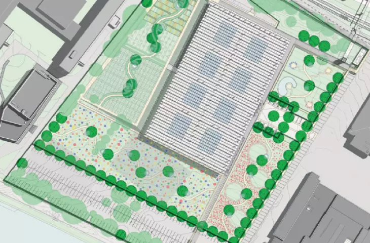 Aerial view of modern rectangular building surrounded by greenery and urban structures