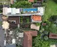 Aerial view of urban area with buildings, roads and greenery; rooftop pool visible