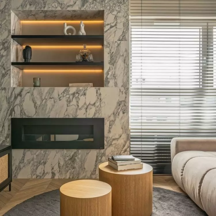 The bi-fireplace in the living room is covered with marble