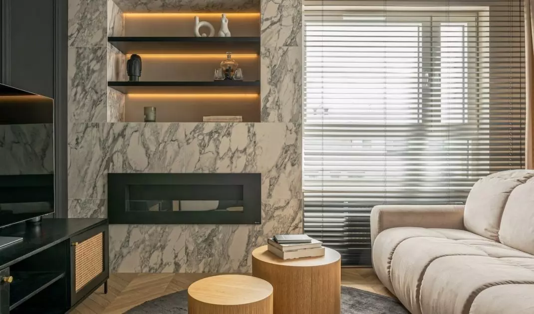 The bi-fireplace in the living room is covered with marble