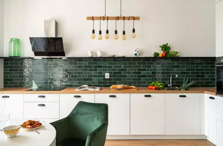 Green subway tiles add variety to a white kitchen