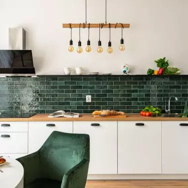Green subway tiles add variety to a white kitchen