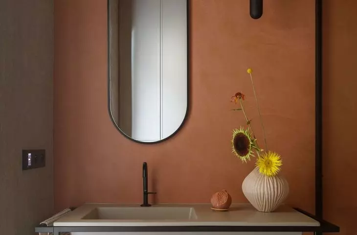 The walls of the bathroom are covered with sintered tiles in the shade of terracotta