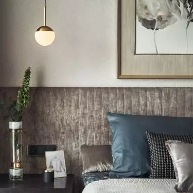 The wall behind the bed was covered with upholstered panels