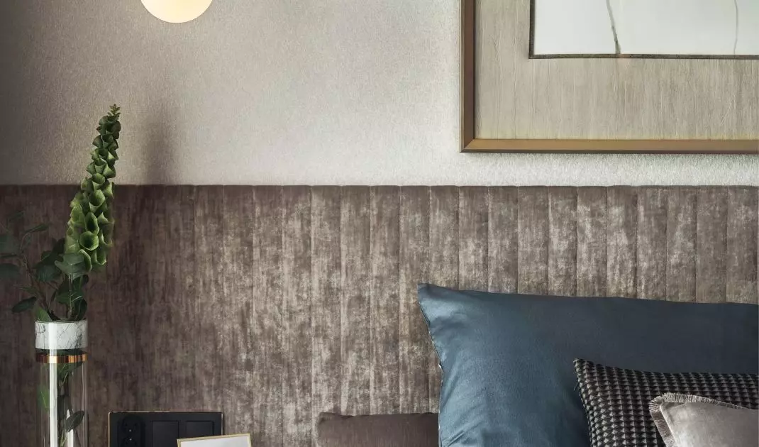 The wall behind the bed was covered with upholstered panels