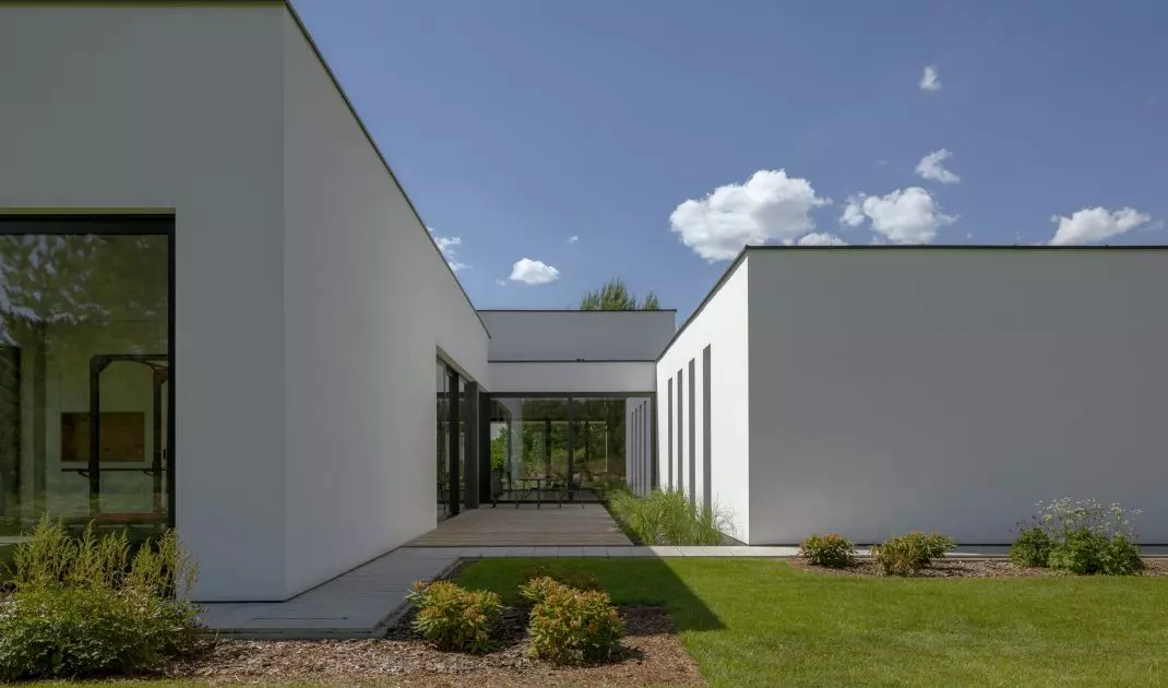 The niches stand out against the white facades thanks to the use of graphite plaster