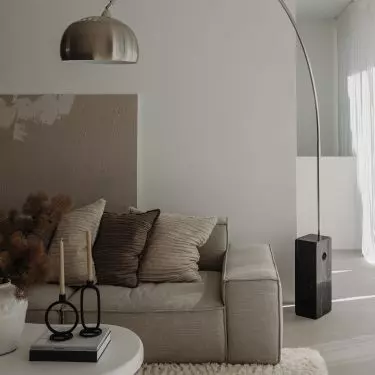 The arched lamp made of metal is a great example of combining rawness with gentleness 